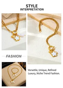Detail of gold necklace set with white enamel flower, butterfly and pearl charms