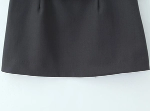 Detail van de grijze mini-rok met hoge taille met nette zoomstiksels en gladde stoftextuur