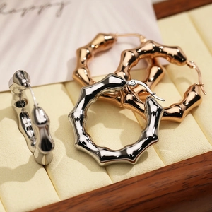 Detail of bamboo shaped hoop earrings in silver and rose gold on a velvet jewelry box