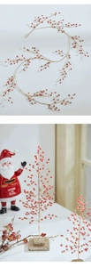 Detailed view of red Christmas berries and golden glitter branches on a desktop tree ornament