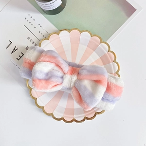 Detail of pink and white striped coral fleece headband with a large decorative bow