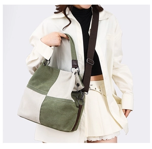 Detail of canvas tote bag with olive green and beige patchwork and wide strap