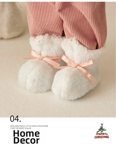 Dettaglio di stivali in peluche bianchi con fiocco di raso rosa per decorazioni natalizie