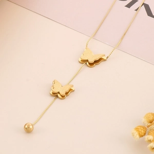 Close-up of double-layered butterfly pendant necklace in a refined gold finish