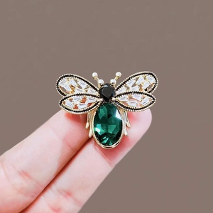 Exquisite gold bee brooch with green crystal body and sparkling rhinestone wings
