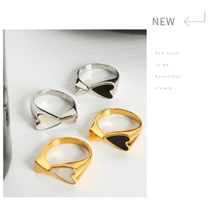 Detail of twisted 18k gold and silver rings with black and white enamel heart designs