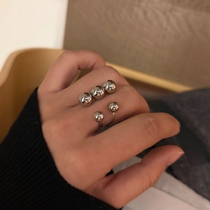 Detailed view of women silver spherical stainless steel ring with five polished beads