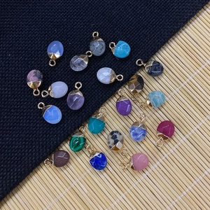 Natural 8x14mm oval blue turquoise pendants with golden caps on dark textured background