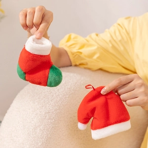 Close-up of soft plush mini Christmas stocking and hat held by hands for holiday decor