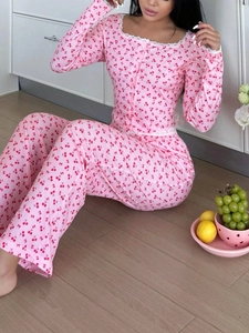 Détail d'un pyjama rose avec imprimé cerises, dentelle et manches longues boutonnées