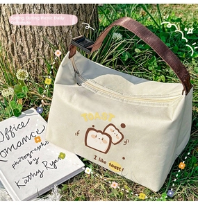 Close-up of insulated lunch bag with cartoon toast print and brown buckle handle