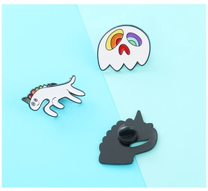 Detail showing the white enamel unicorn and ghost pins with black rubber backings