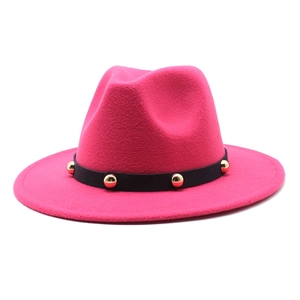 Detail of rose red wool felt fedora with black decorative band and golden rivets