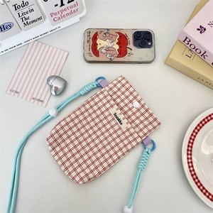 Close-up of red checkered fabric phone bag with blue braided rope and metal snap