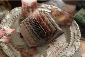 Detail of vintage scrapbooking paper with red roses fanned out on a white plate