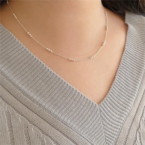 Close-up of minimalist S925 sterling silver bead necklace worn on a female neck