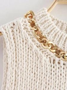 Detail of cream chunky knit top featuring premium gold metal chain link accents