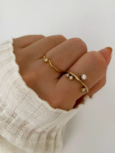 Close-up of minimalist 18K gold plated titanium steel rings with zircon settings