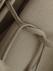 Detail of khaki woven linen fabric texture and waist tie on the elegant two-piece set