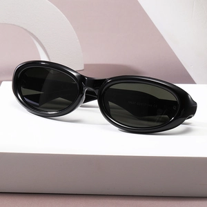Classic black oval contrast sunglasses for women on a minimalist geometric white stand