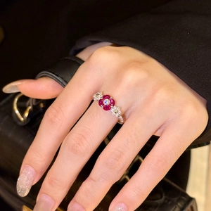 Close-up of zircon red flower ring on finger featuring vintage crystal detailing