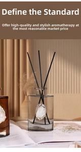 Detailed view of gray glass diffuser bottle with golden-edged agate stone and fiber reeds