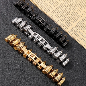 Three punk style bullet links bracelets in black, gold, and silver on vintage newspaper