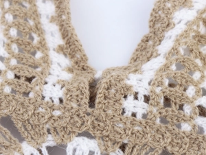 Detailed macro view showing the intricate crochet knit texture and hollow pattern of the vest