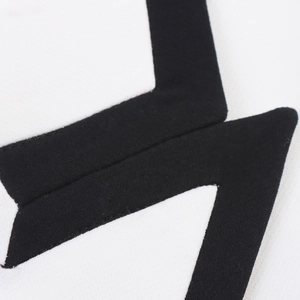 Macro detail of black geometric embroidery on white cotton fabric shorts