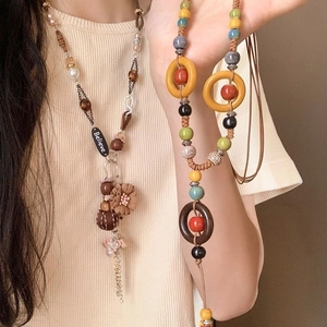 Bohemian sweater necklace with vintage wood beads and Believe pendant on beige knit