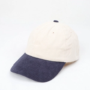 Close-up of the vintage corduroy texture on the beige and navy blue baseball cap