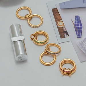 Macro detail of layered gold-plated titanium rings with white, green, blue and pink zircons