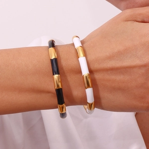 Minimalist 18K gold plated stainless steel enamel bangles in black and white on model