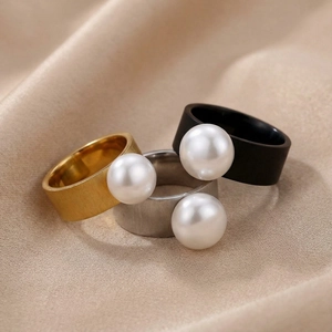 Detailed close-up of a three-piece ring set with large white pearls and brushed metal finish