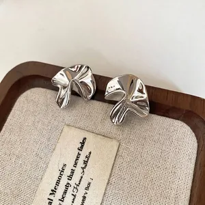 Polished silver irregular floral studs with abstract metallic folds and minimalist design