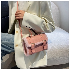 Close-up of pink faux fur and suede crossbody bag with decorative buckle straps