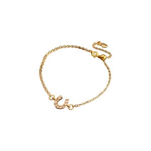 Bracelet fer à cheval plaqué or minimaliste avec oxydes de zirconium sur fond blanc