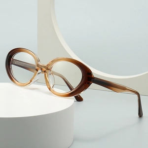 Modern oval cat-eye sunglasses in amber brown gradient on a minimalist pedestal