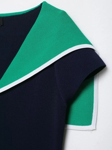 Detail of contrast lapel collar on navy and green knit top with fine white piping