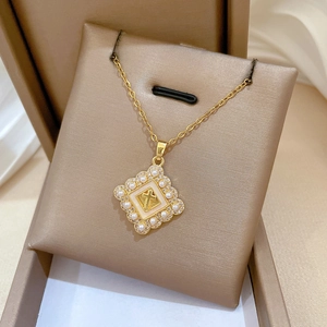 Macro view of gold cross pendant with pearls and rhinestones in a jewelry gift box