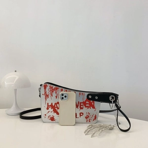 Detail of cleaver-shaped crossbody bag with red blood splatters for Halloween theme