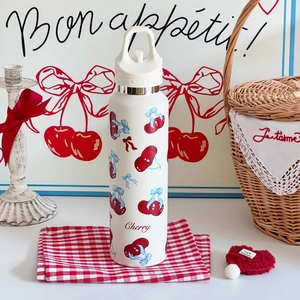 Detail einer weißen Isolierflasche mit Kirschmuster, Tragegriff und Trinköffnung
