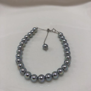 Detail of gray peacock pearls and silver adjustable chain with lobster clasp