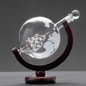 Detailed view of globe whiskey decanter with internal glass ship on a wooden stand