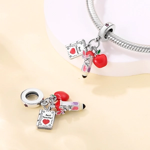 Detailed view of Best Teacher charms featuring a silver book, red apple, and pink pencil