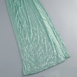 Detail of mint green sequin dress fabric with an elegant side slit and shimmering texture