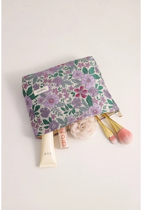 Close-up of floral embroidery texture and interior storage of this purple makeup bag