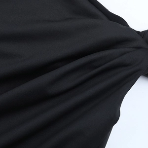 Close-up of black knit fabric texture and fine stitching on a slim-fit long sleeve top