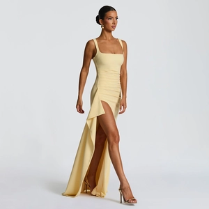 Détail d'une robe de soirée jaune avec encolure carrée et fente haute avec drapé élégant