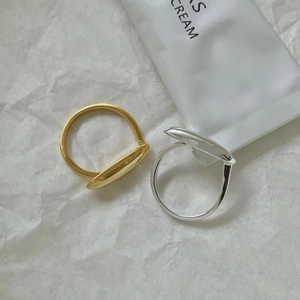 Anelli aperti minimalisti in argento e oro con design geometrico su carta con texture